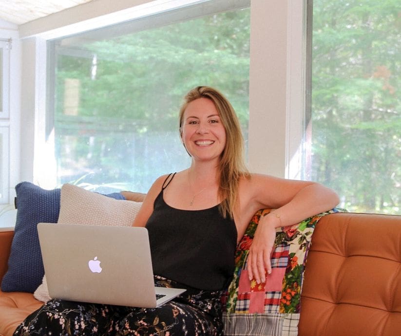 Picture of Jenna Smiling at the Camera with her Laptop on her Lap